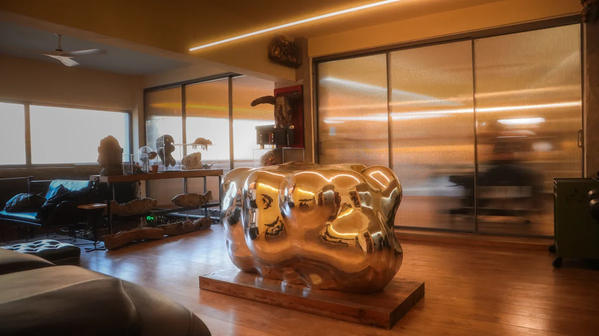 Lei Shi Tattoo studio gallery space featuring a large polished chrome abstract sculpture — fine art meets tattoo culture